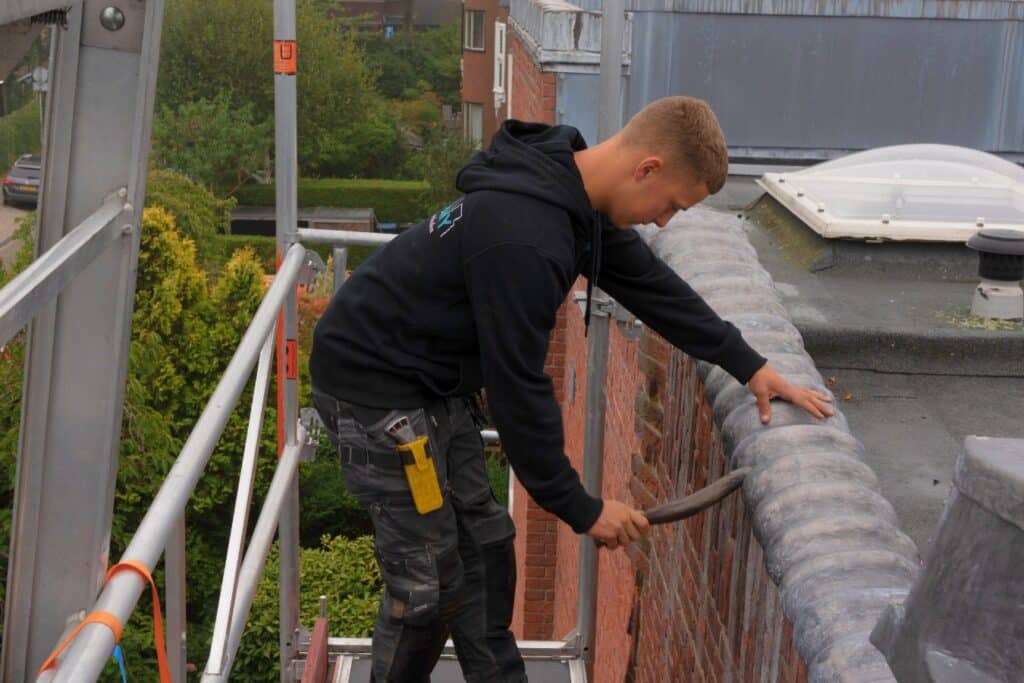Dakcompany aan het werk bij een dakrand bezig met het lood en zinkwerk